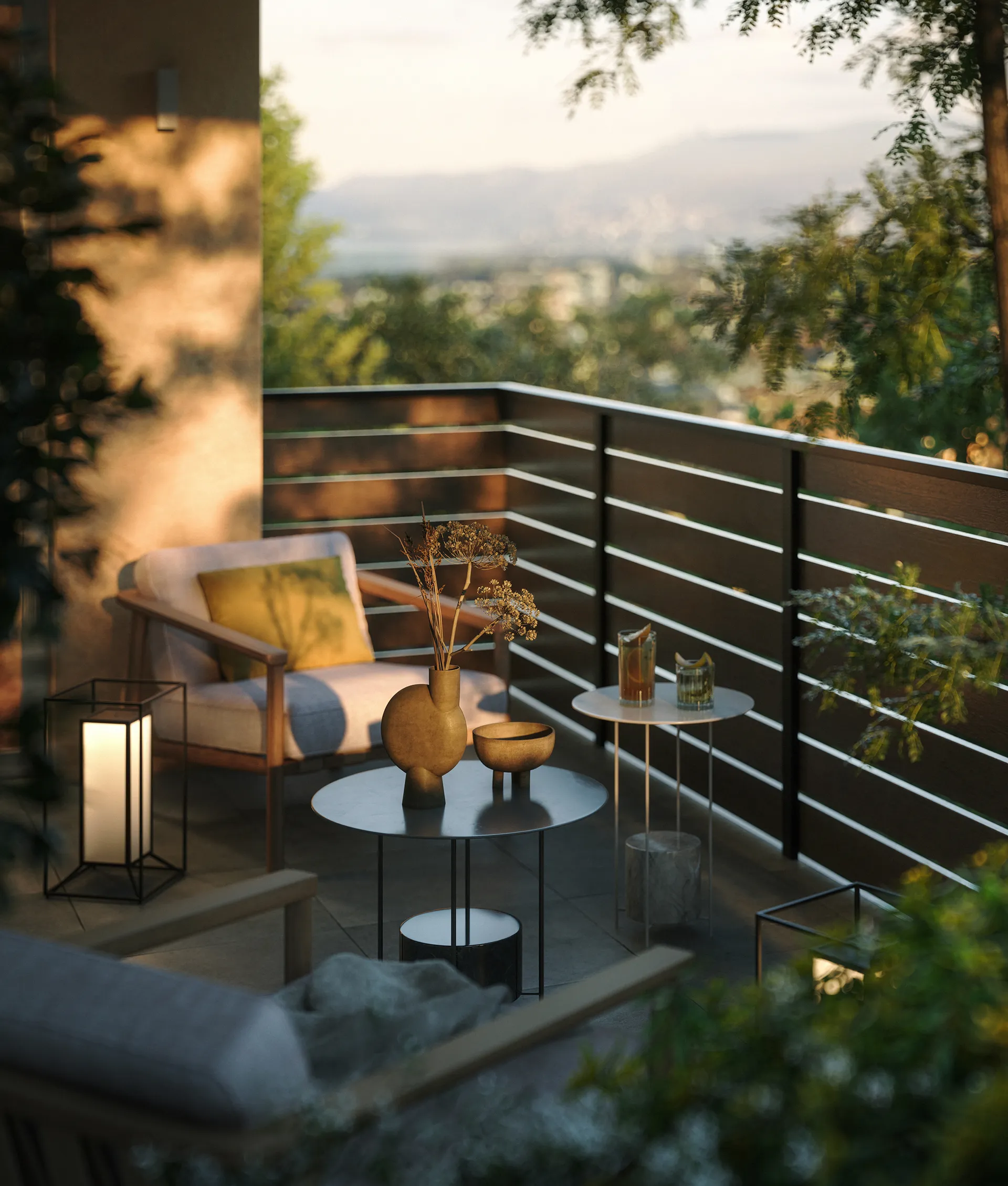 Balcone moderno con due poltrone, tavolini con vaso e ciotola, e lanterne luminose al tramonto.